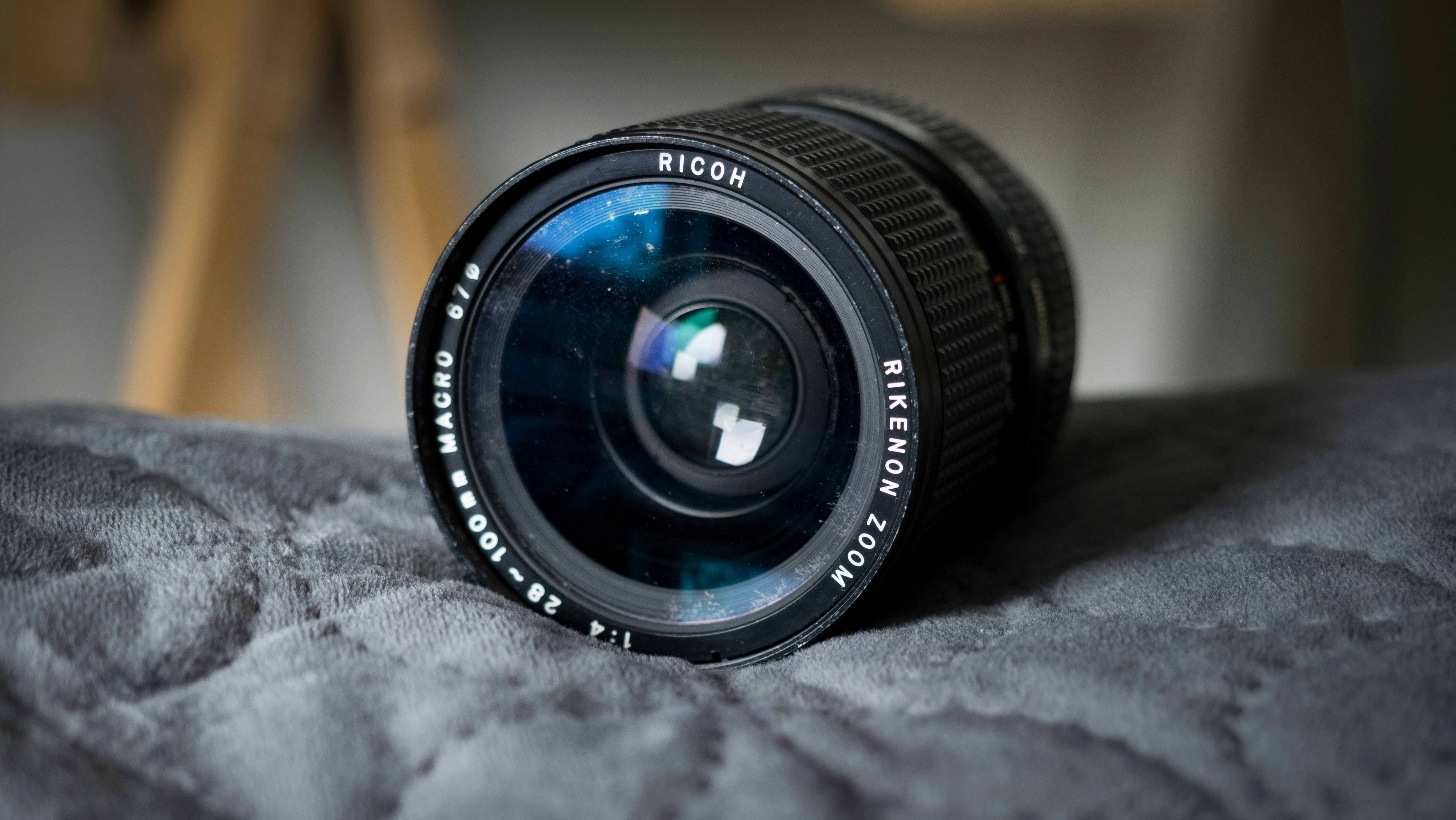 black nikon camera lens on gray textile